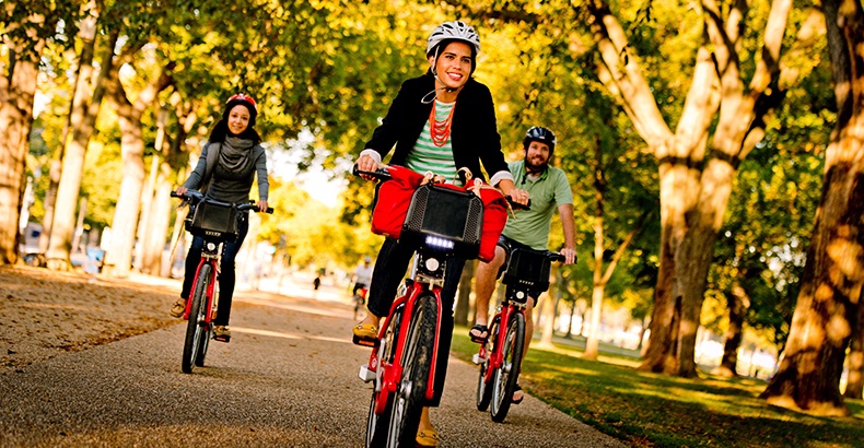 Three people riding Capital Bikeshare bikes on a trail