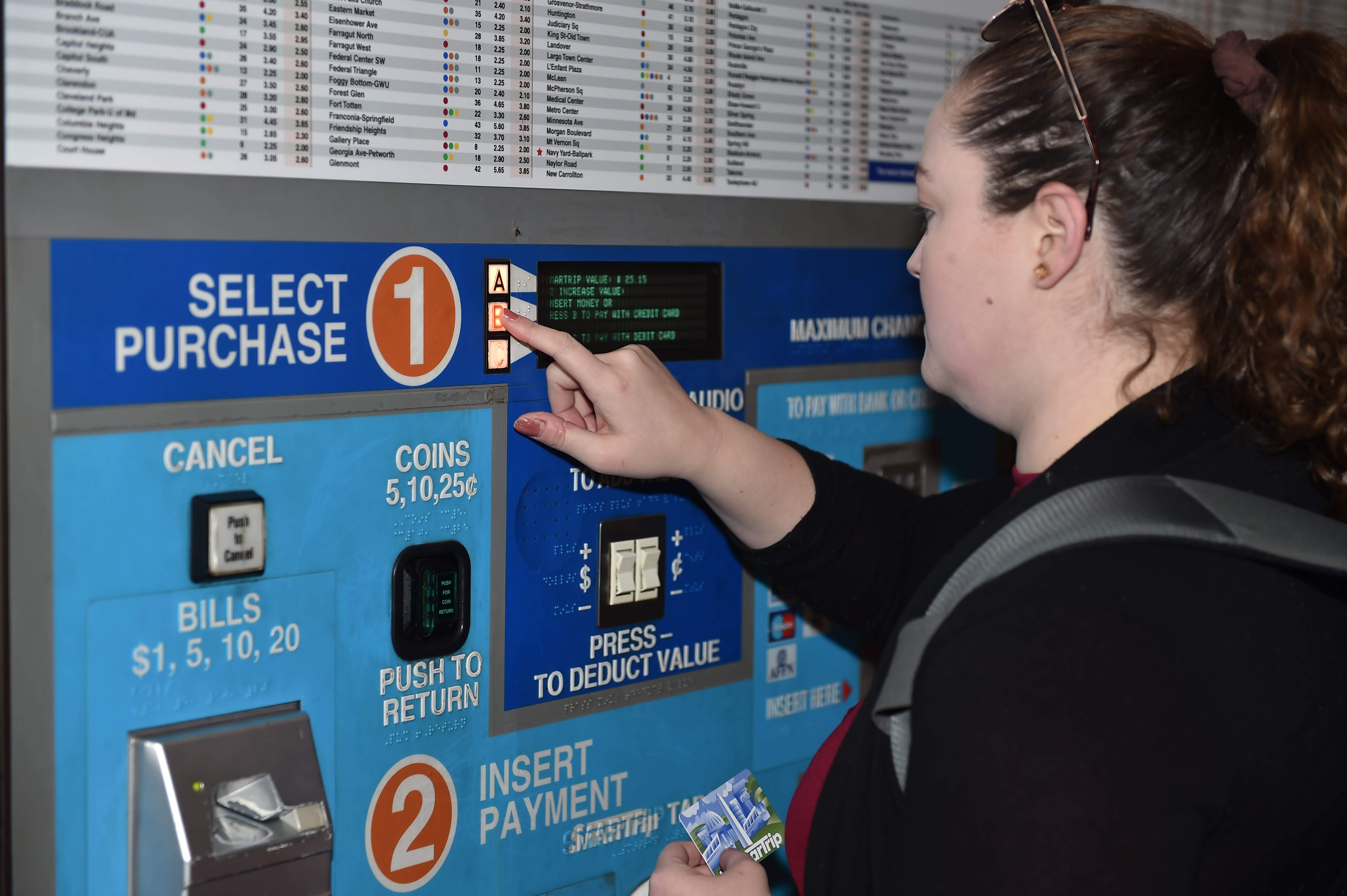 Woman using a metro pay station